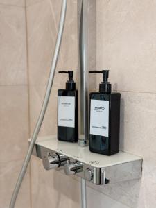 two bottles of soap on a shelf in a bathroom at Luxury Apartments Marz in Schwanau +13 photos