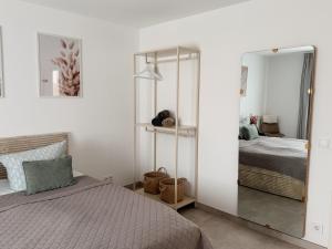 a bedroom with a mirror next to a bed at Luxury Apartments Marz in Schwanau