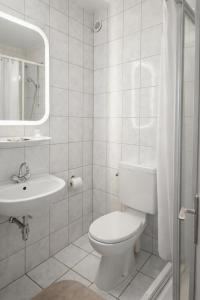 a white bathroom with a toilet and a sink at Waldhotel Bad Münstereifel in Bad Münstereifel +21 photos