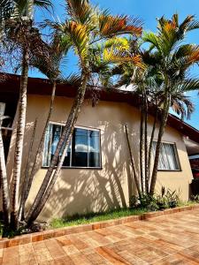 a group of palm trees in front of a house at La casita in Foz do Iguaçu