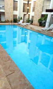 a large blue swimming pool in a hotel at Agréable appartement familial avec Piscine - City Center in Fez