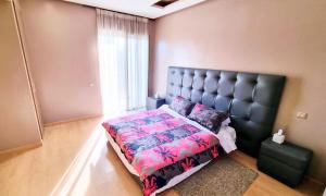 a bedroom with a bed and a large window at Agréable appartement familial avec Piscine - City Center in Fez +11 photos