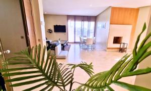 a living room with a couch and a table at Agréable appartement familial avec Piscine - City Center in Fez