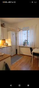 a kitchen with a refrigerator and a table and a window at Karlskrona centrum in Karlskrona