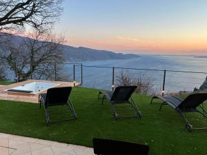 a group of chairs sitting on a lawn with a hot tub at Villa dei Roveri in Tignale +13 photos