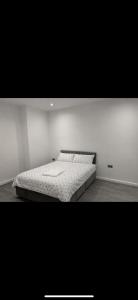 a bedroom with a bed in a white room at The Coach House in Bradford +2 photos