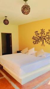a bedroom with a large white bed with two lights at Laguinn Hotel Acapulco in Acapulco