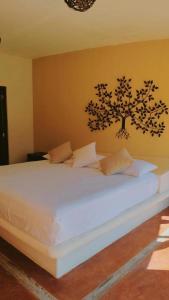 a bedroom with a white bed with a tree on the wall at Laguinn Hotel Acapulco in Acapulco +18 photos