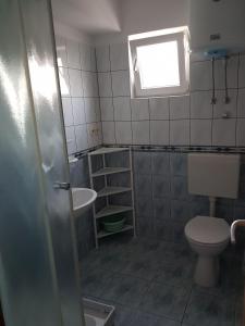 a bathroom with a toilet and a sink and a window at Apartments Sea and Pine in Ivan Dolac +23 photos