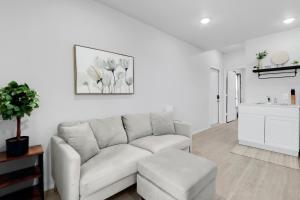 a white living room with a couch and a stool at The Container Retreat - 1A.. in Canyon Lake