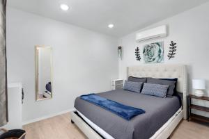 a bedroom with a bed with blue pillows and a mirror at The Container Retreat - 1A.. in Canyon Lake