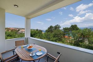 a balcony with a table and chairs and a large window at Apartment Karmen in Šilo