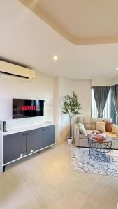 a living room with a couch and a tv on a wall at 12th Floor Studio Tambuli, Sea View, Balcony in Maribago