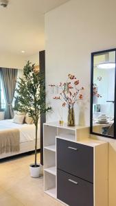 a bedroom with a bed and a dresser with a tree at 12th Floor Studio Tambuli, Sea View, Balcony in Maribago +16 photos
