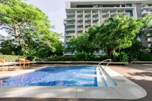 a swimming pool with two chairs and a building at 12th Floor Studio Tambuli, Sea View, Balcony in Maribago