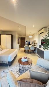 a hotel room with a bed and a living room at 12th Floor Studio Tambuli, Sea View, Balcony in Maribago