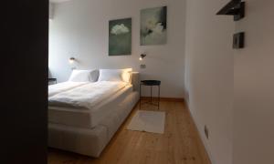 a white bedroom with a bed and a table at La casa del lupo in Colico