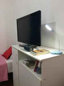 a computer monitor on a white desk with a lamp at Lo del Tata in Villa Unión