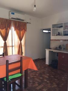 a room with a table and a kitchen with a counter at Lo del Tata in Villa Unión