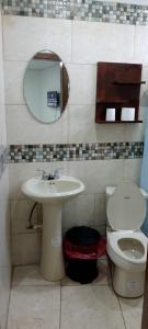 a bathroom with a sink and a toilet and a mirror at Apartamento INRU in Puerto Cortés
