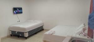 a hospital room with two beds and a sink at Apartamento INRU in Puerto Cortés