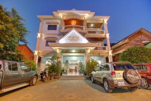 a building with cars parked in front of it at DV Angkor Villa in Siem Reap