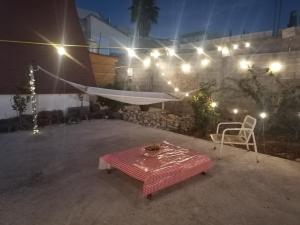 a patio with a table and a chair and lights at Cabaña Alpina Saltillo in Saltillo