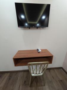 a desk with a television on a wall with a chair at Hotel & Plaza San Blas in Comayagua