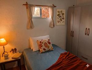 a small bedroom with a bed and a window at Refugio El Dormilón, Jardín cercado, Wifi, Playa 300 m, Pet friendly in La Pedrera