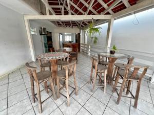 a patio with tables and chairs on a balcony at Casa com churrasqueira e ar para até 8 pessoas in Guabiruba
