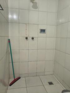 a white tiled shower with a green toothbrush in it at Pousada Esperança - Areias SP in Areias +12 photos