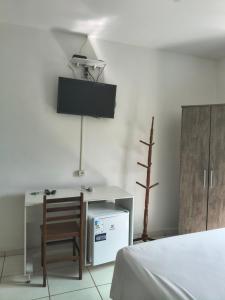 a room with a bed and a desk and a chair at Pousada Esperança - Areias SP in Areias