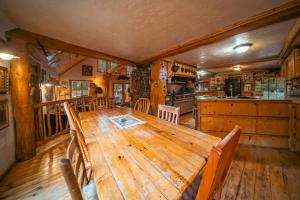 a large wooden table in a room with a kitchen at Campfire Ranch All-Inclusive Lodge in Truckee