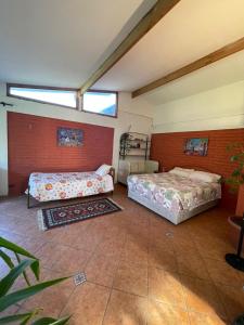 two beds in a room with two windows at Casa Ordóñez - Cielo Abierto in El Molino