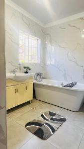 a bathroom with a tub and a sink at Jwalaboholo Mountain View Guest House in Ficksburg +61 photos