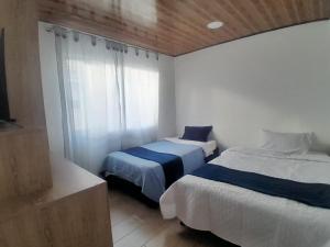 a bedroom with two beds and a window at Alojamiento y Confort in Tunja