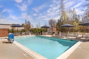 a large swimming pool with chairs and umbrellas at Best Western Plus Glen Allen Inn in Richmond