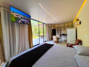 a bedroom with a large bed with a large window at Bosque dos Buritis in Araguaína