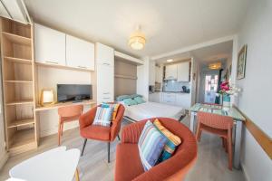 a small room with a bed and chairs in it at Sea-view garden-level flat in Ploemeur