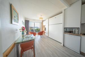 a kitchen and dining room with a table and chairs at Sea-view garden-level flat in Ploemeur