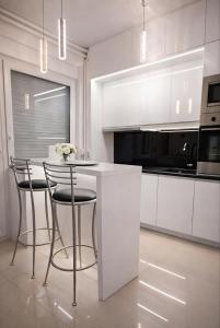 a white kitchen with a table and chairs at AR Vila Kikinda in Kikinda +42 photos