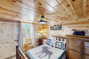 a bedroom with a bed in a log cabin at Meandering Moose Cabin in Florissant