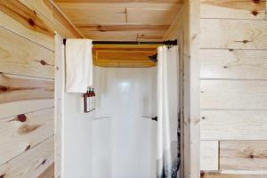 a bathroom with a shower in a wooden wall at Meandering Moose Cabin in Florissant +11 photos