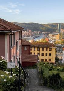 a walkway leading down to a city with buildings at BILBAO ENEA - Apartamento 2 habitaciones cerca de San Mamés in Bilbao