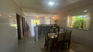 a kitchen and dining room with a table and chairs at Casa com churrasqueira e piscina, perto de riacho in Angra dos Reis
