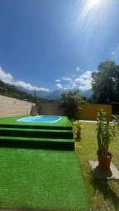 a swimming pool in a yard with green grass at Casa com churrasqueira e piscina, perto de riacho in Angra dos Reis
