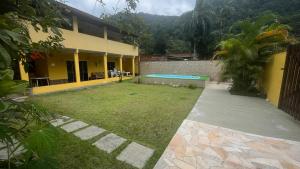 a backyard of a house with a swimming pool at Casa com churrasqueira e piscina, perto de riacho in Angra dos Reis