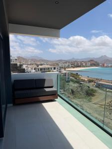 a balcony with a couch and a view of the ocean at Boa Vista Apartment in Prainha