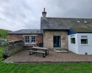 a house with a picnic table in front of it at Midhope Castle Cottages in Queensferry