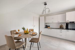 a kitchen with a table and chairs in a room at Luxury Apartment Marz in Schwanau